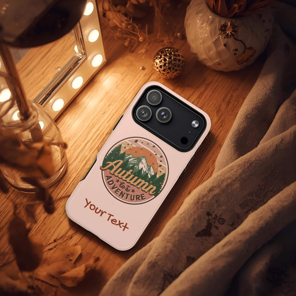 Phone case with 'Autumn Adventure' design on a wooden surface with warm lighting