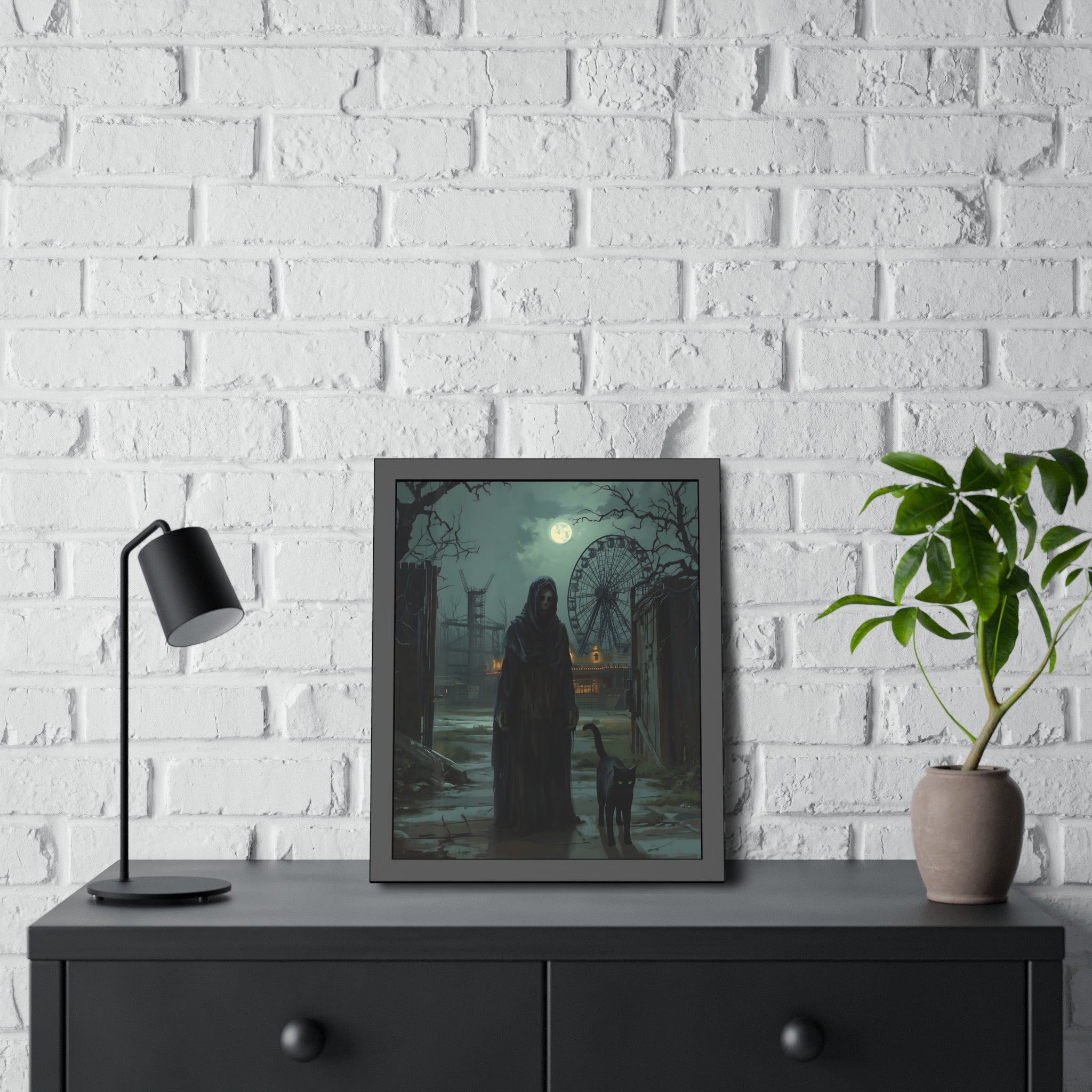 Framed artwork of a silhouette in a dark setting on a white brick wall with a lamp and plant.