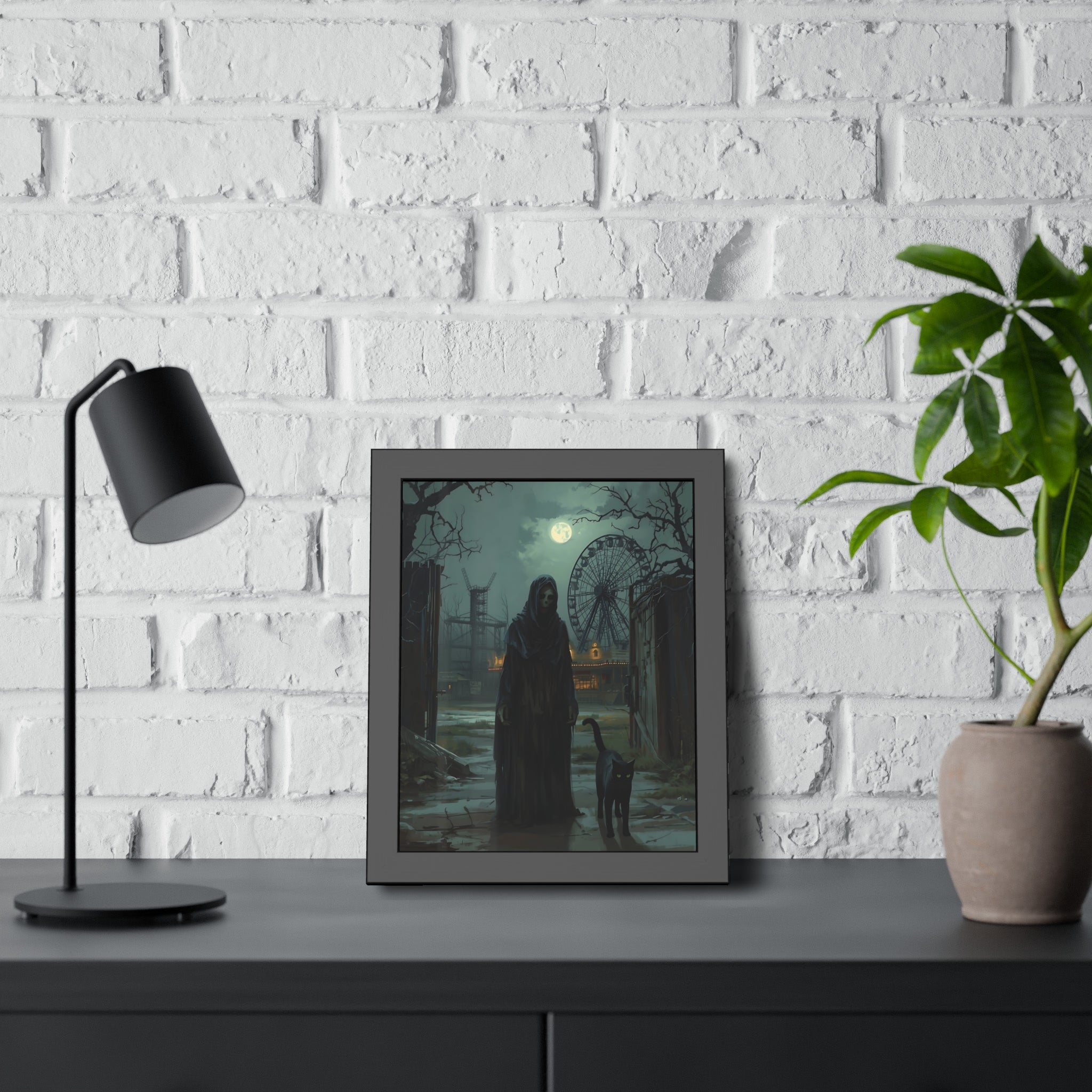 Framed artwork of a dark scene with a figure and a child on a table against a white brick wall.