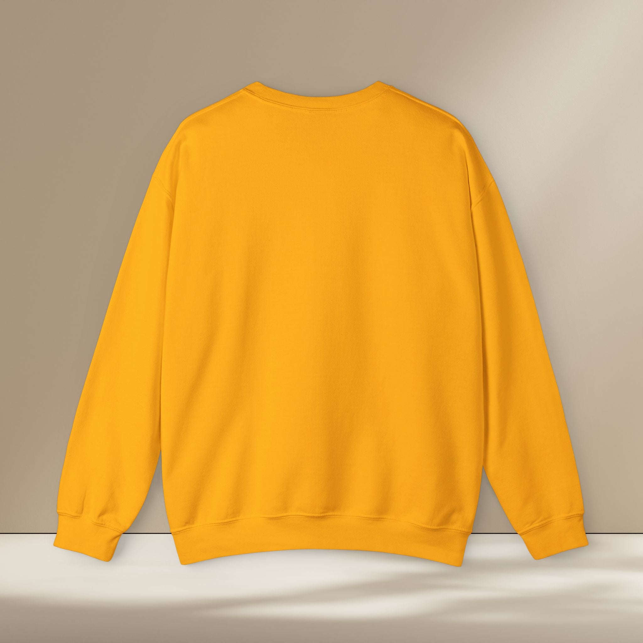 Yellow sweatshirt on a white surface with a beige background