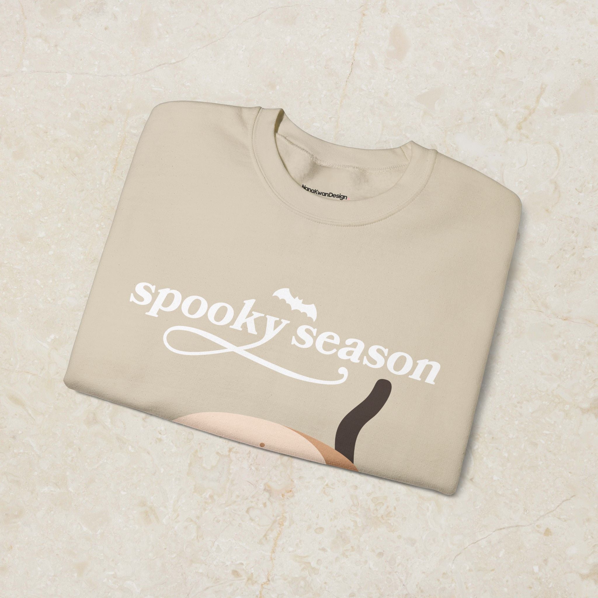 Beige sweatshirt with 'spooky season' text and graphic on a beige background